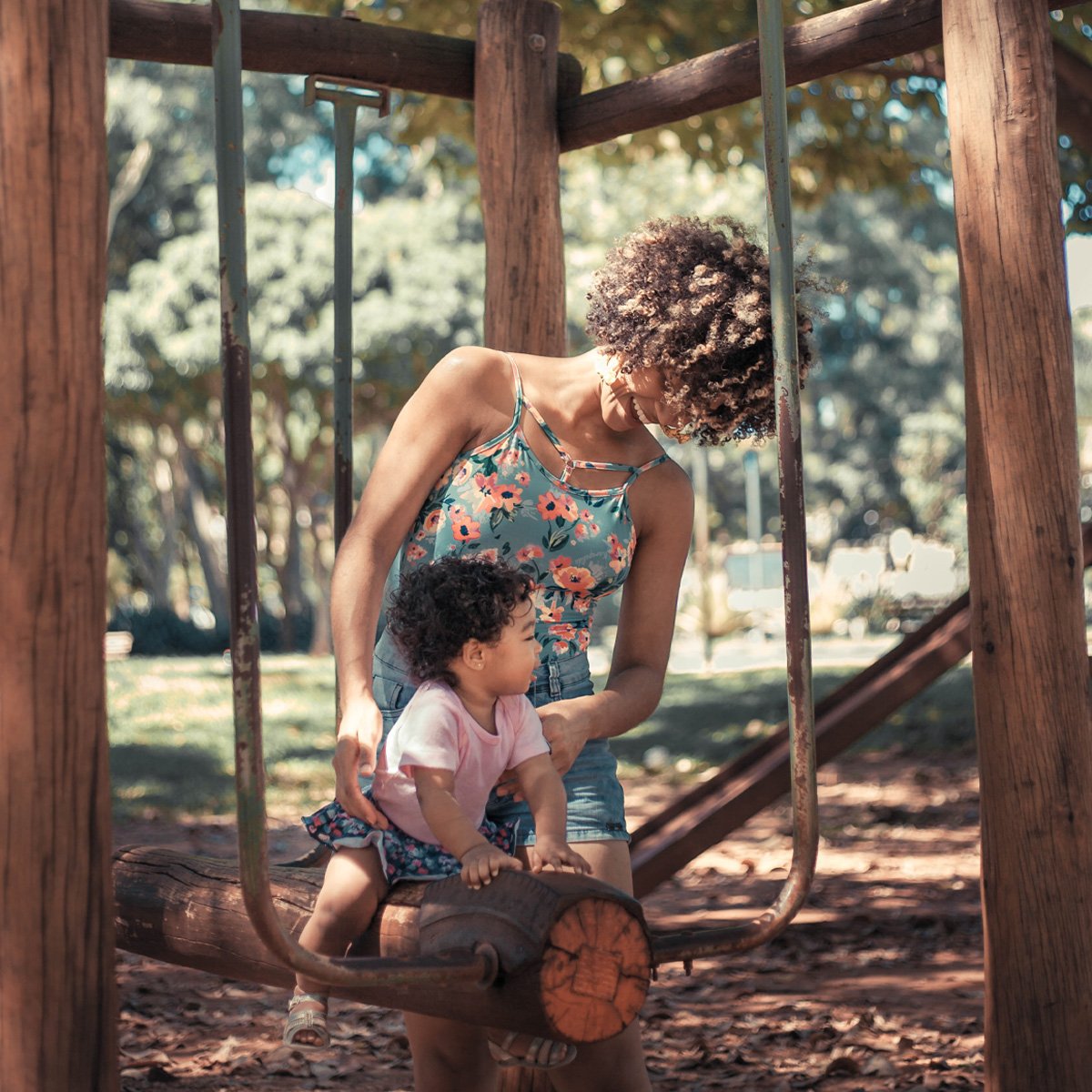 Mother and child playing at the park, connecting with nature.