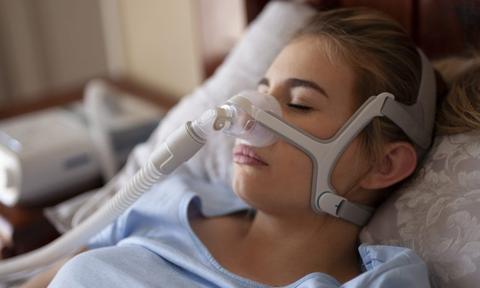 young woman sleeping with nasal cpap mask on