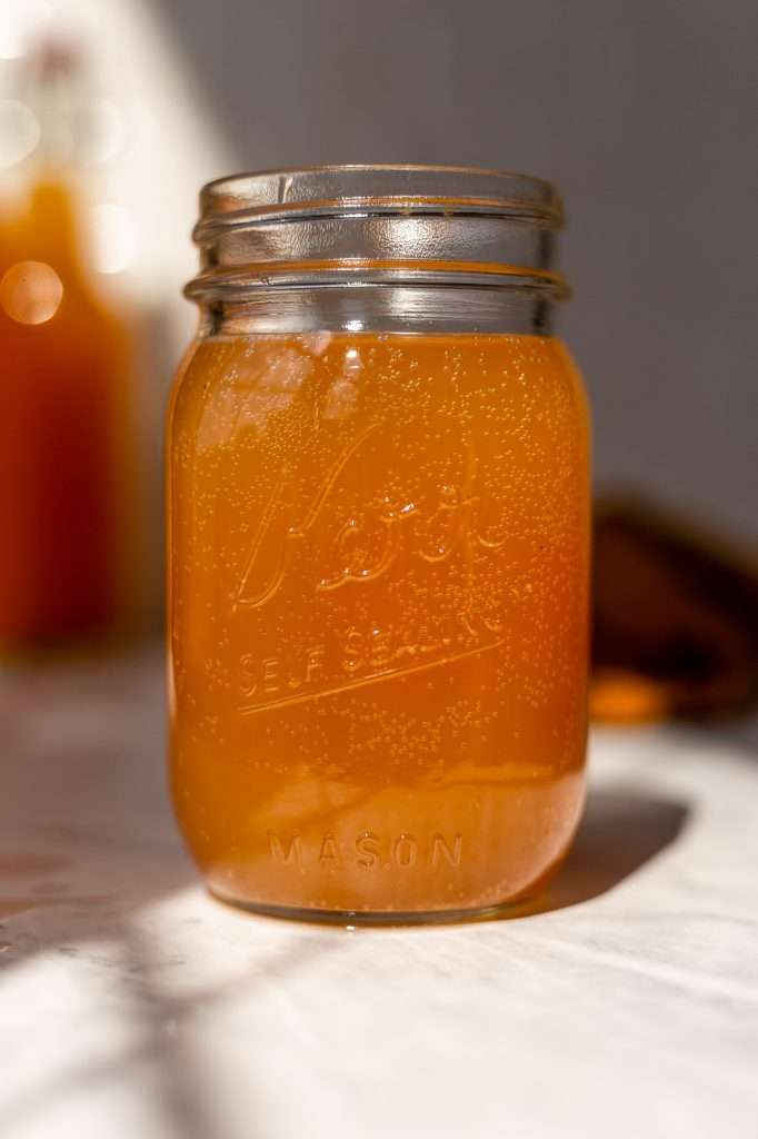 carbonated Golden beet kvass after the two parts of fermentation. It's poured in a glass mason jar and ready to drink. 