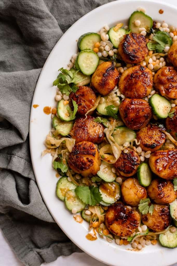 honey butter blackened scallops on a bed of cucumber couscous salad. 