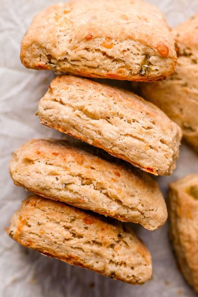 a close up view of the side of four kimchi cheddar biscuits showing the flaky layers in each biscuit