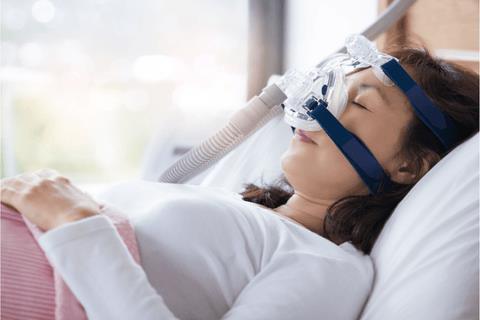 A woman wearing a CPAP mask while sleeping