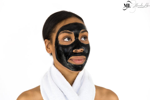 Woman with a charcoal face mask - Skincare treatment