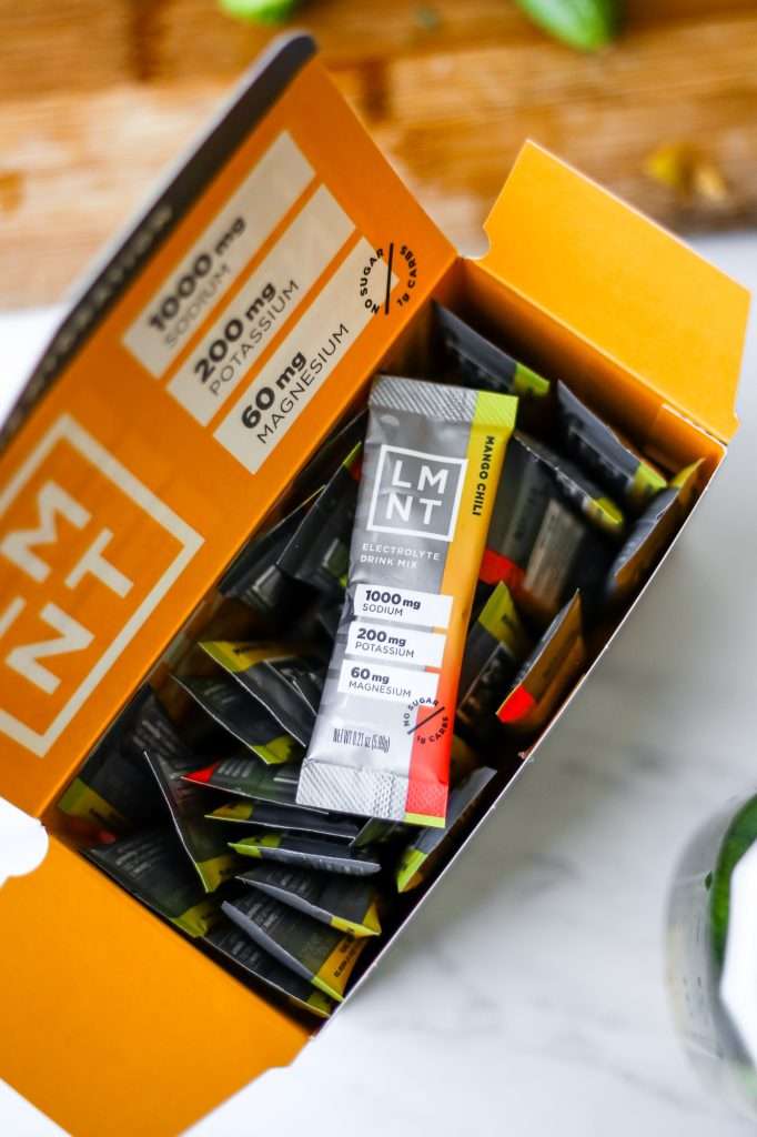 a box of mango chili flavored LMNT electrolytes. One packet sits on top the rest to show the principle display panel. 